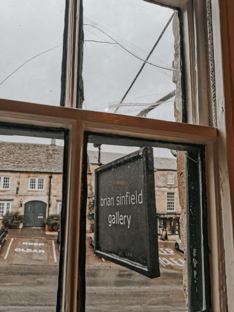 The sign hanging outside the window of the Brian Sinfield Gallery.
