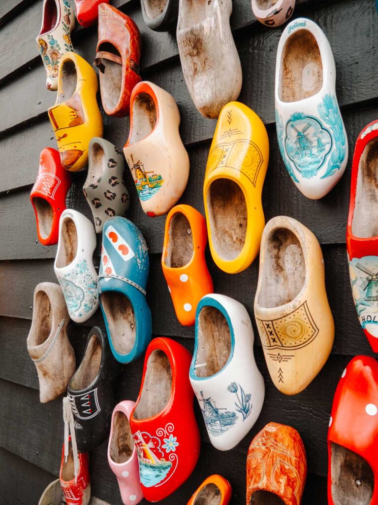 Dutch wooden clogs on display outside the clog workshop in Zaanse Schans. The clogs are painted in a wide variety of colours and patterns such as polkadots and leopard print. 