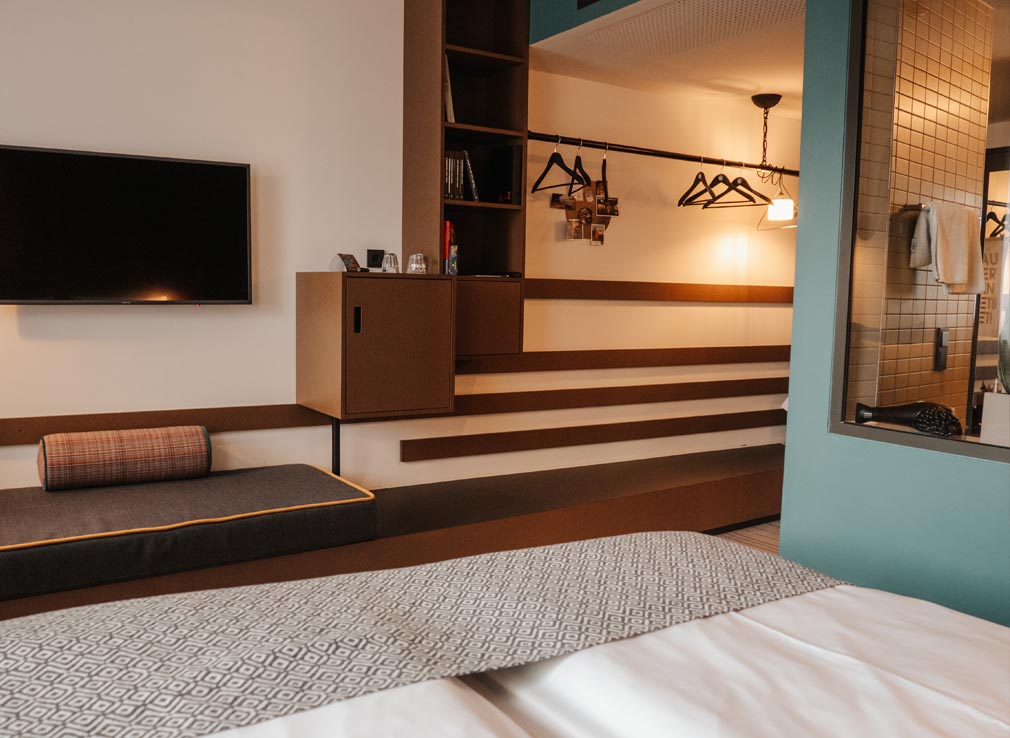 The medium plus room at Pierdrei Hotel Hafencity. In this photo, you can see a bit of the bed, bathroom, sofa, shelfing area and wardrobe space. It also showcases the sheer size of the room.