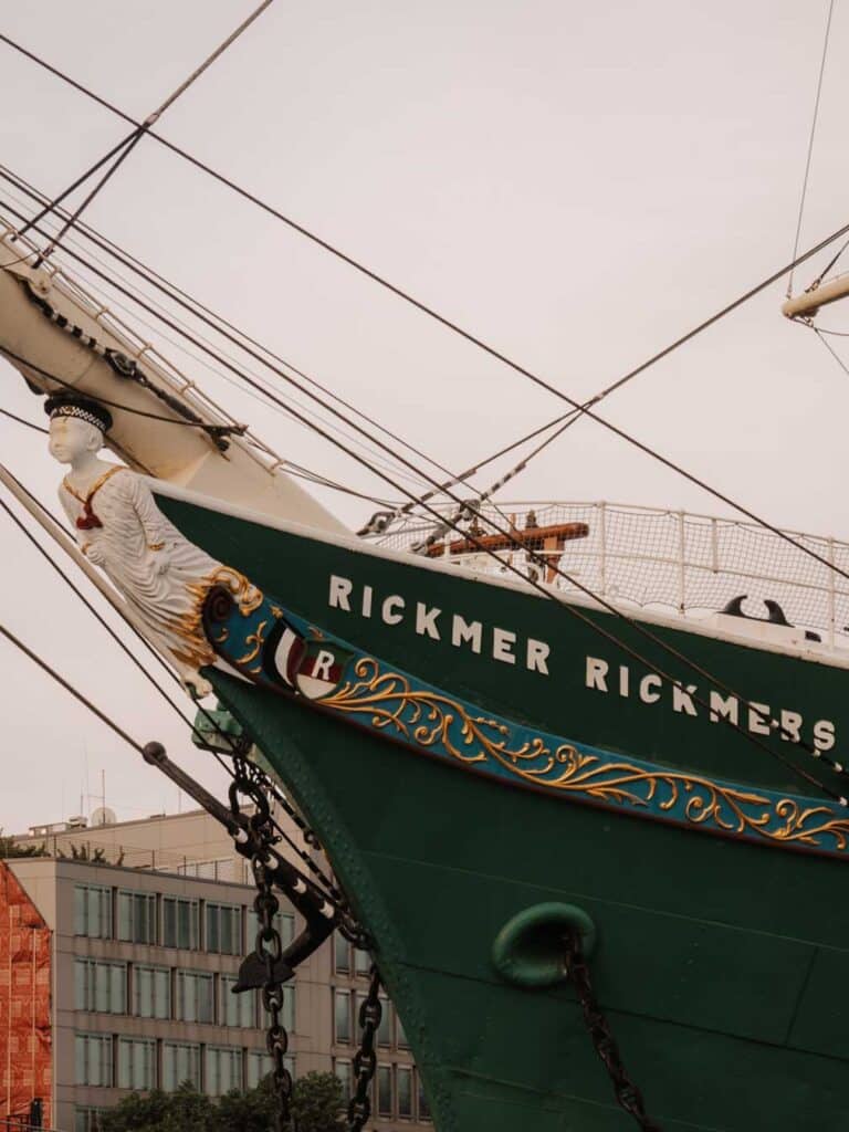 The exterior of Rickmer Rickmers which is a must-see attraction in Hamburg if you enjoy maritime history. Rickmer Rickmers is a green boat, with blue, white and gold painted details and it's situated on St. Pauli Piers.