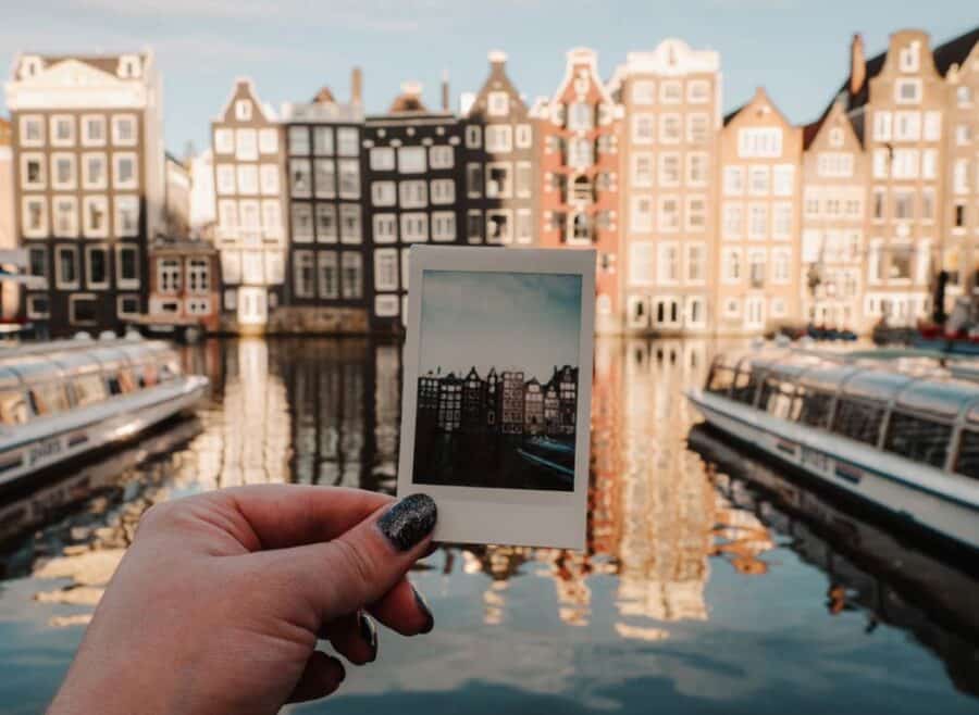 Lauren holding a polaroid photo that she took of the Damrak in Amsterdam on a sunny day