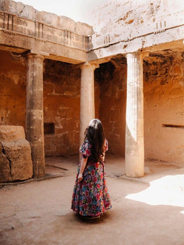 Lauren admiring the tall ancient columns at the Tombs of the Kings.