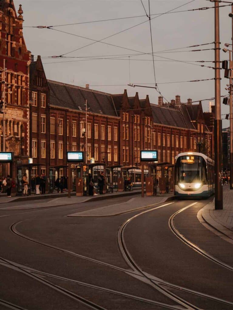 Trams outside Centraal Station during sunset.