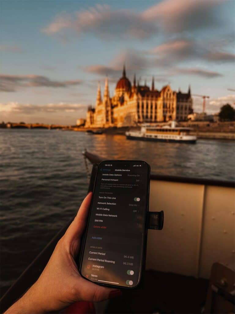 Checking my Sim Local eSIM connection while cruising along the Danube River in Budapest with views of the Hungarian Parliament in the distance