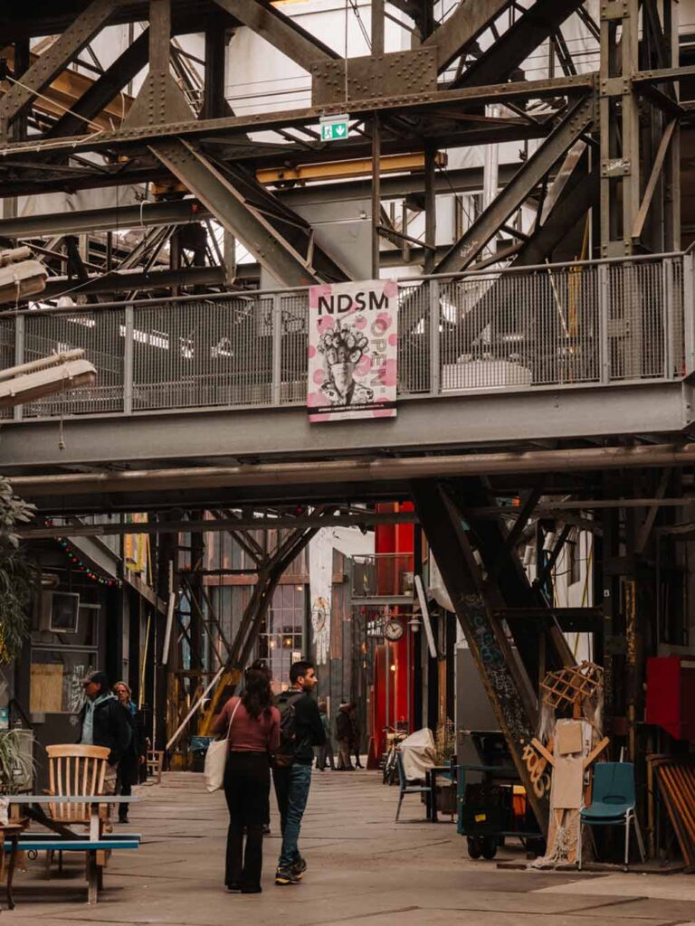 People walking around NDSM Loods in Amsterdam.